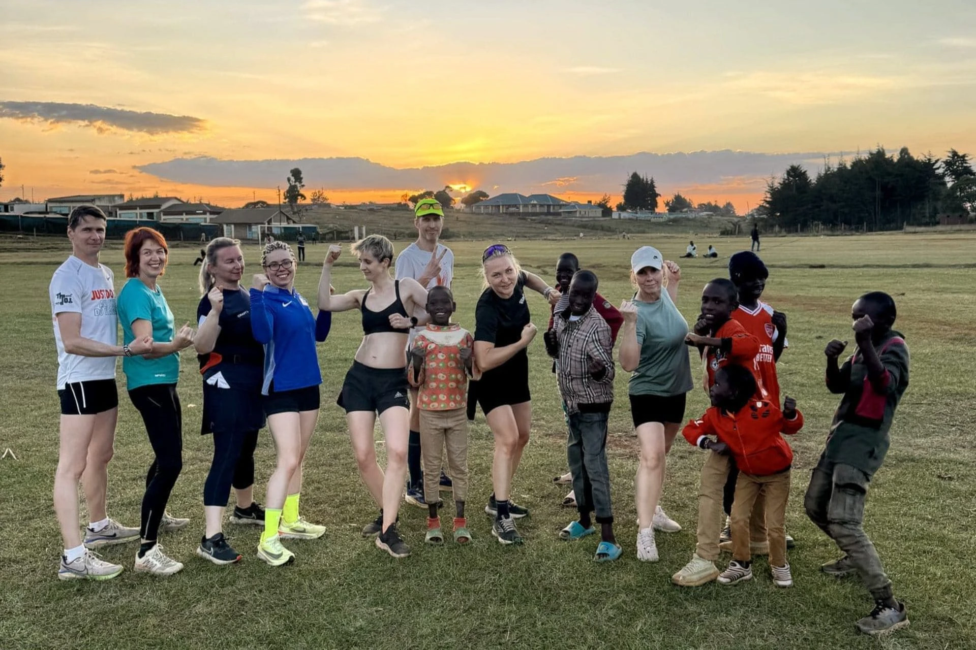 Eesti jooksureisi grupp ja kohalikud lapsed päikeseloojangus Itenis